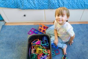 Junge spielt auf Kinderteppich